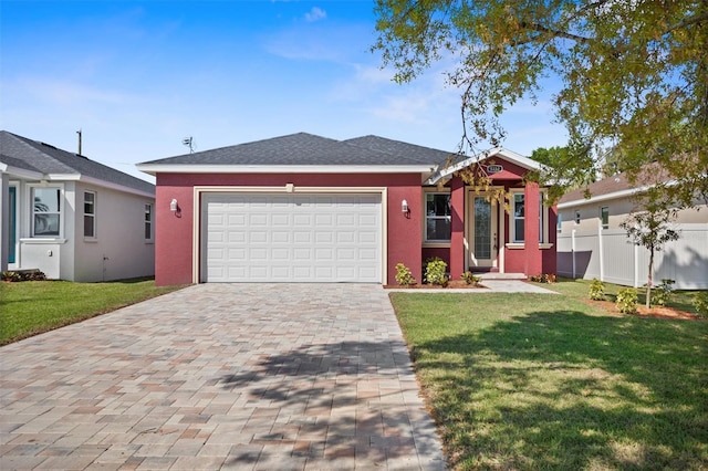 view of front facade with decorative driveway, a garage, fence, and a front lawn