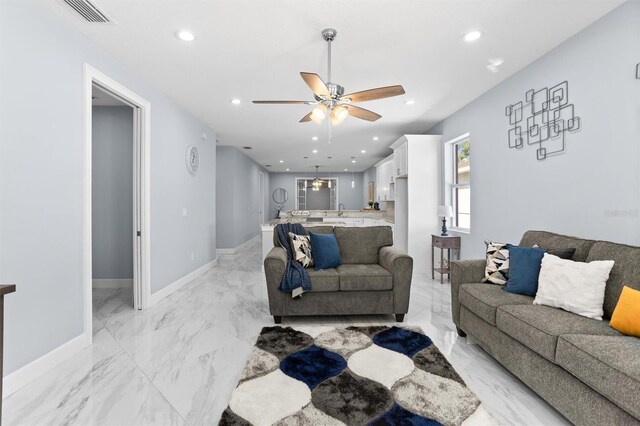 living area featuring marble finish floor, baseboards, recessed lighting, and a ceiling fan