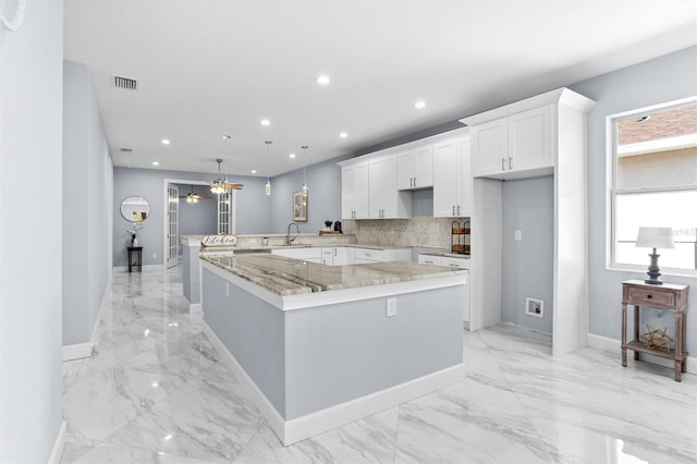 kitchen with tasteful backsplash, recessed lighting, a sink, visible vents, and white cabinets