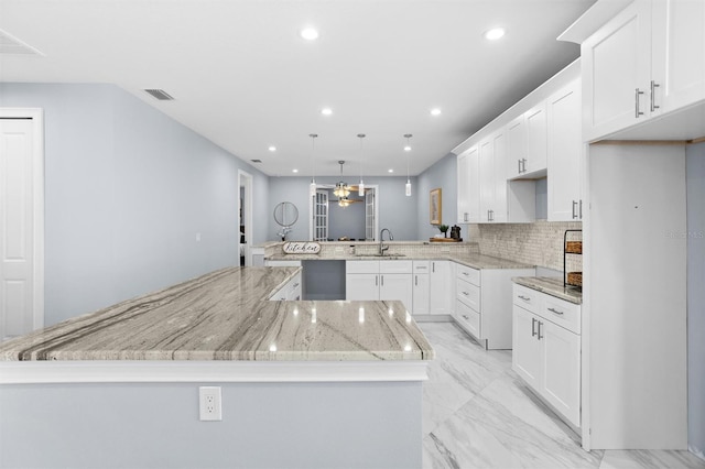 kitchen featuring marble finish floor, visible vents, recessed lighting, and a sink