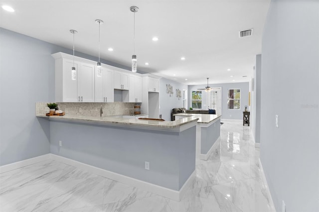 kitchen with marble finish floor, white cabinetry, visible vents, and tasteful backsplash