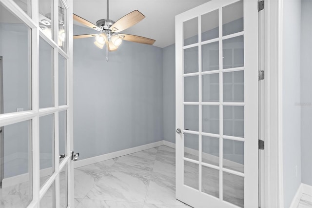 unfurnished room with baseboards, marble finish floor, ceiling fan, and french doors