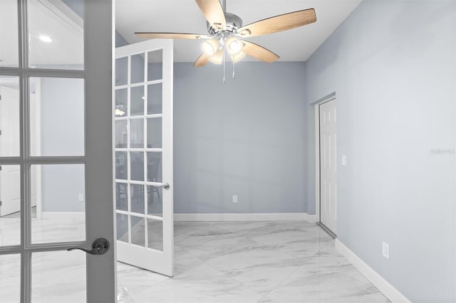 unfurnished room with marble finish floor, baseboards, french doors, and a ceiling fan