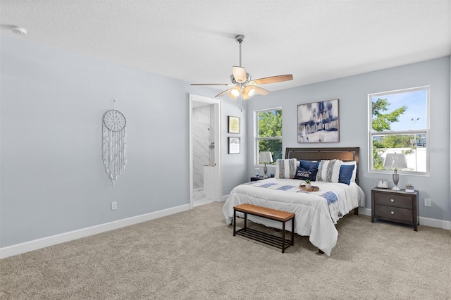 bedroom featuring connected bathroom, carpet floors, a ceiling fan, a textured ceiling, and baseboards