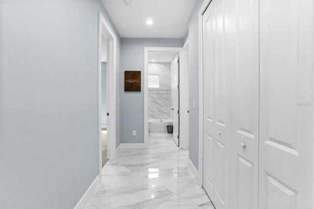 hallway with baseboards, marble finish floor, and recessed lighting