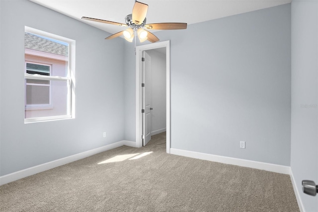 spare room featuring baseboards, carpet, and a ceiling fan