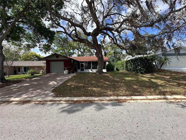 single story home with a front yard, concrete driveway, and an attached garage