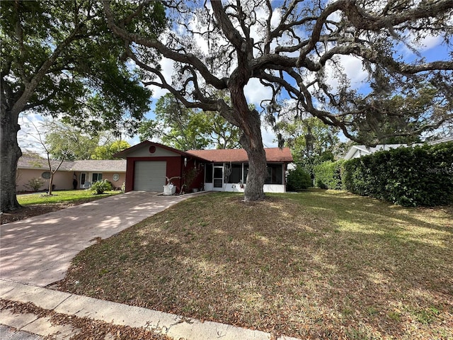 ranch-style house featuring a front lawn, a sunroom, a garage, and concrete driveway