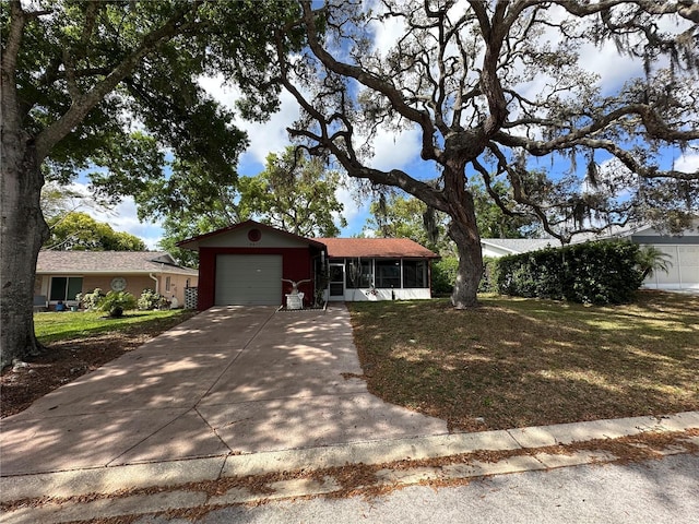 single story home featuring a sunroom, concrete driveway, a front lawn, and an attached garage