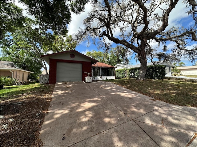 view of home's exterior with a lawn, a sunroom, concrete driveway, and an attached garage