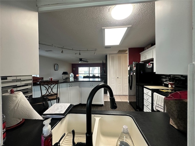 kitchen featuring a ceiling fan, white cabinets, a textured ceiling, dark countertops, and black appliances