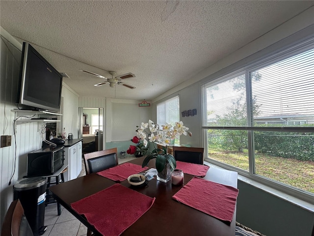 dining room featuring light tile patterned floors, a textured ceiling, and a ceiling fan