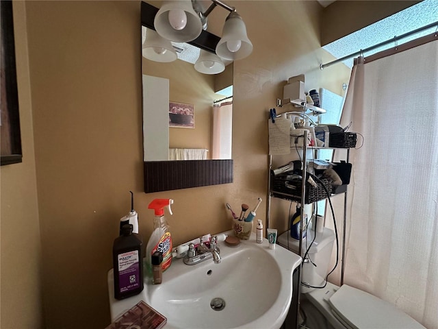 full bathroom featuring a shower with curtain, toilet, and a sink