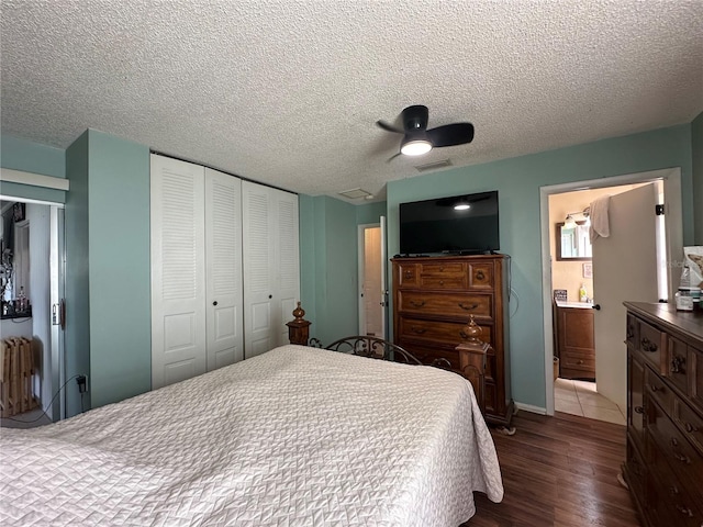 bedroom featuring a closet, a textured ceiling, visible vents, and dark wood-type flooring