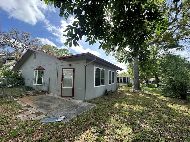 back of house featuring a patio, stucco siding, fence, and a yard