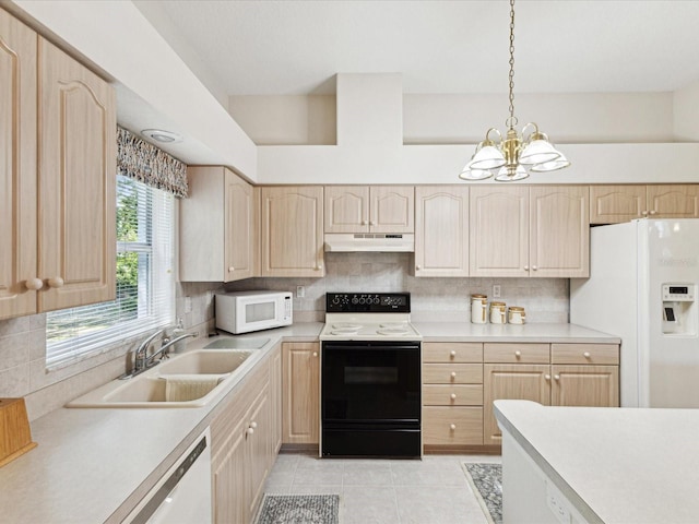 kitchen with light countertops, a sink, under cabinet range hood, light brown cabinets, and white appliances