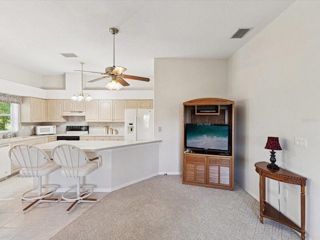 kitchen with light countertops, visible vents, under cabinet range hood, and white appliances