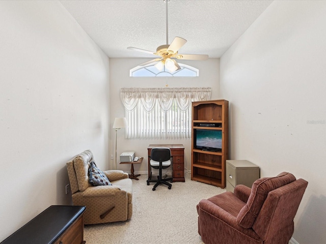 living area featuring a textured ceiling, carpet, and a ceiling fan