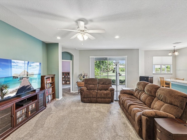 11050 Kiskadee Cir, New Port Richey, FL 34654 - carpeted living area with arched walkways, healthy amount of natural light, a ceiling fan, a chandelier, and a textured ceiling