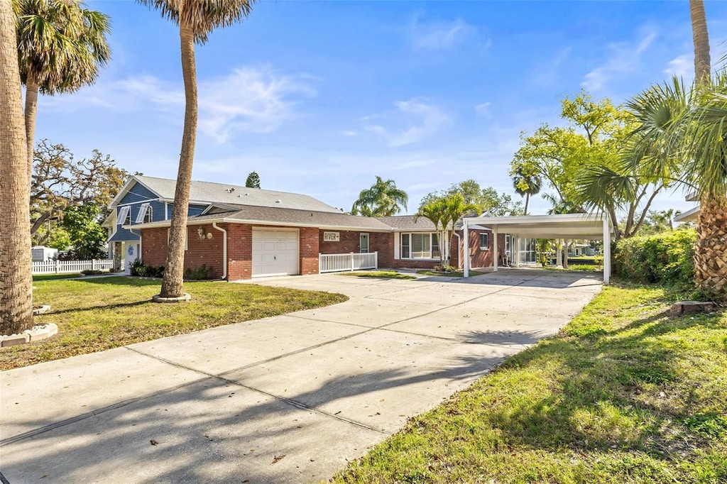view of front of house featuring an attached garage, brick siding, concrete driveway, and a carport
