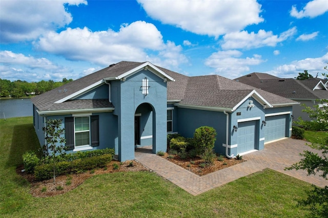 view of front of property featuring driveway, roof with shingles, stucco siding, an attached garage, and a front lawn