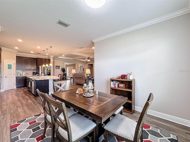 dining space featuring baseboards, dark wood-type flooring, crown molding, and visible vents