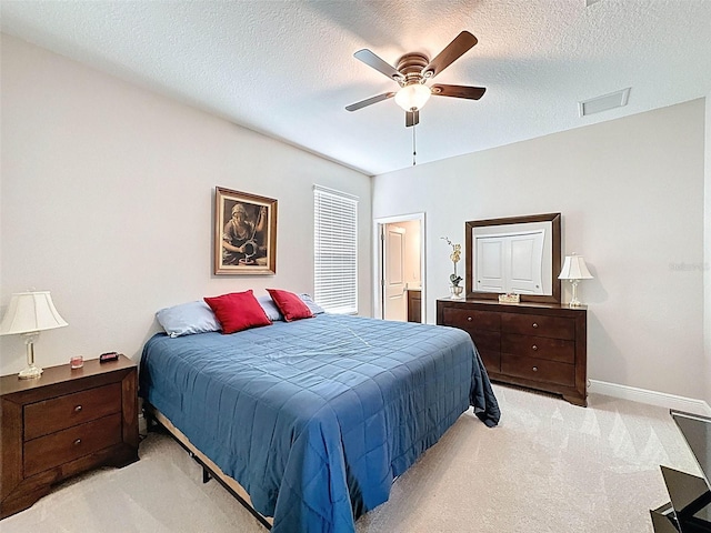 bedroom featuring baseboards, a textured ceiling, visible vents, and light carpet