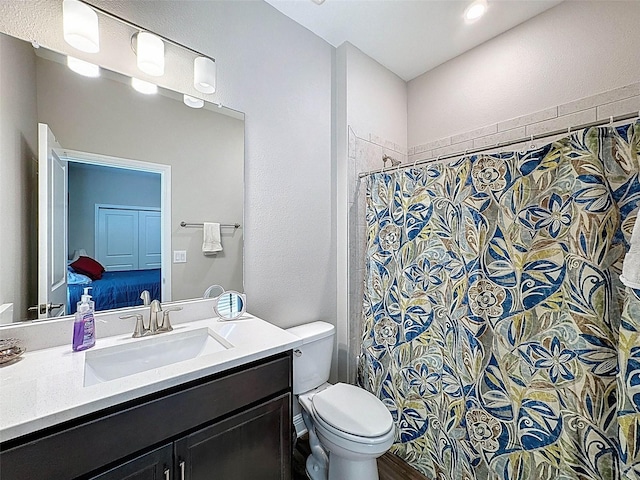 bathroom featuring curtained shower, toilet, and vanity