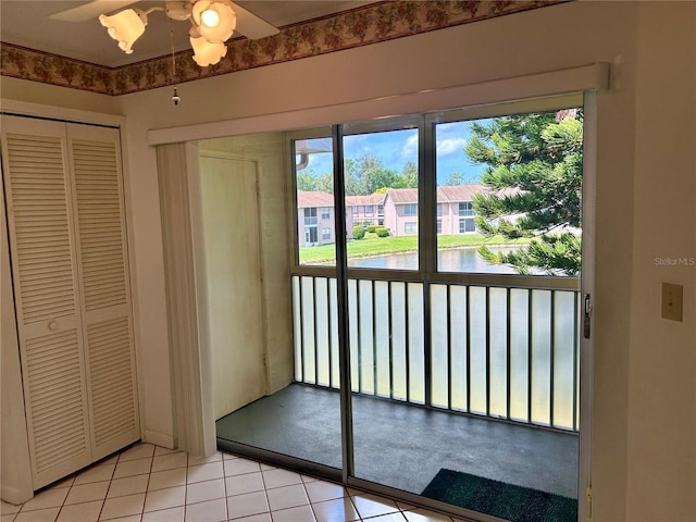 doorway to outside with light tile patterned flooring, a residential view, and a water view