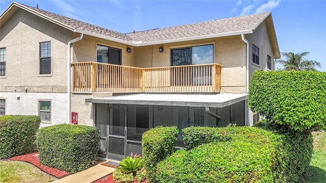 7382 SE Concord Pl, Hobe Sound, FL 33455 - rear view of house with stucco siding, a sunroom, and a balcony