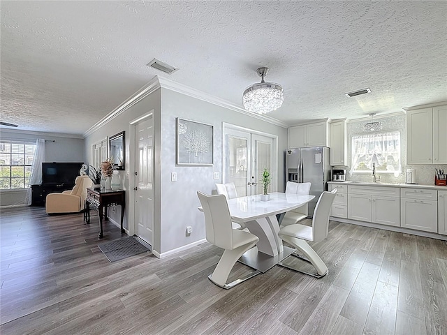 7382 SE Concord Pl, Hobe Sound, FL 33455 - dining space featuring visible vents, a textured ceiling, light wood-style flooring, and a chandelier