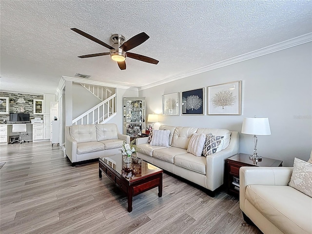 7382 SE Concord Pl, Hobe Sound, FL 33455 - living area featuring crown molding, ceiling fan, a textured ceiling, visible vents, and stairway