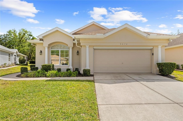 ranch-style house featuring stucco siding, driveway, a garage, and a front yard