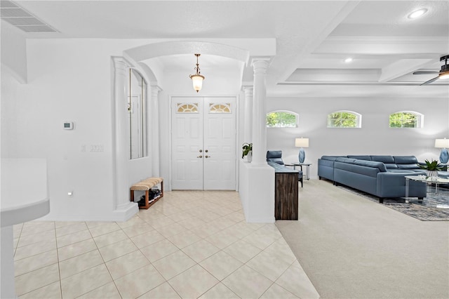 foyer with visible vents, decorative columns, beam ceiling, arched walkways, and light colored carpet