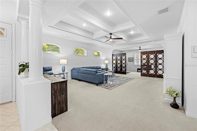 carpeted living room with decorative columns, visible vents, arched walkways, and ceiling fan