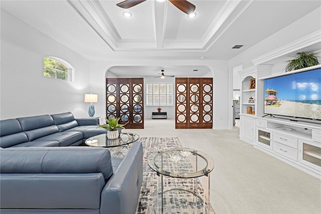 living area with light carpet, visible vents, arched walkways, and a ceiling fan