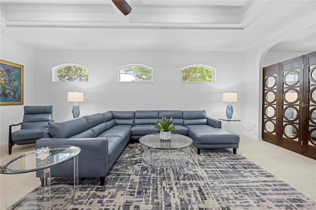 carpeted living room featuring arched walkways, crown molding, and plenty of natural light