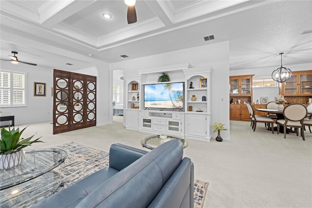 living area with coffered ceiling, light colored carpet, ceiling fan with notable chandelier, beam ceiling, and visible vents
