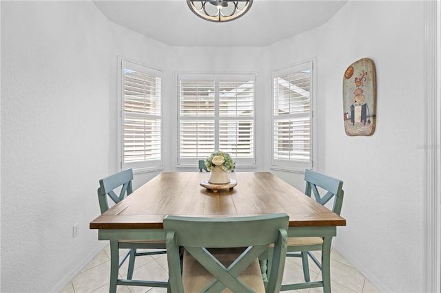 dining room featuring an inviting chandelier, light tile patterned flooring, and baseboards
