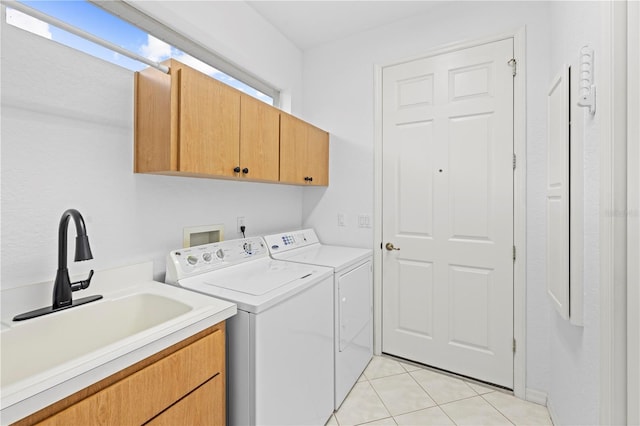 laundry room with light tile patterned flooring, washer and dryer, cabinet space, and a sink