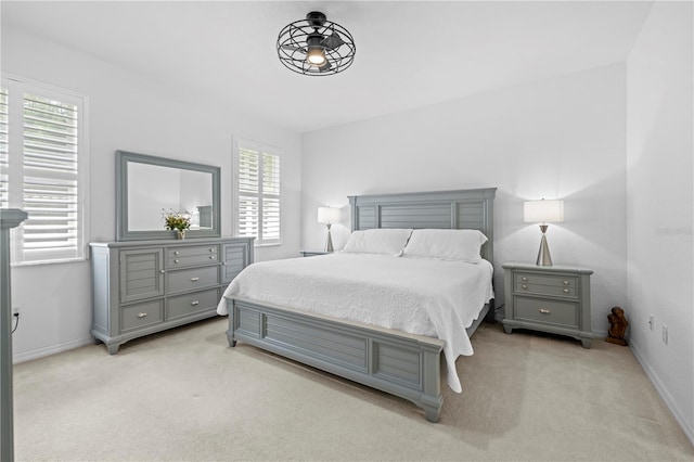 bedroom featuring light colored carpet and baseboards