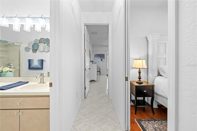 ensuite bathroom featuring visible vents, a shower with shower door, connected bathroom, tile patterned floors, and vanity