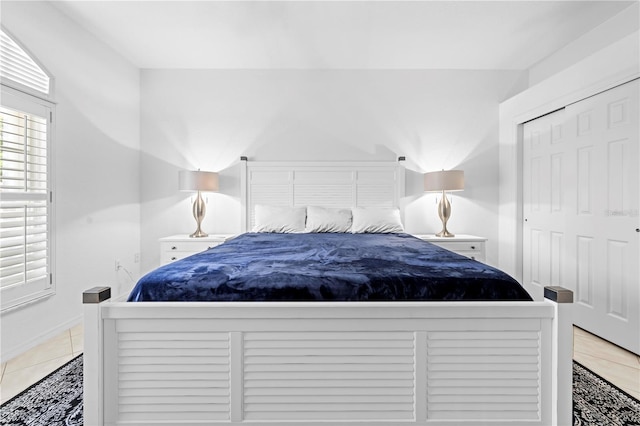 bedroom with light tile patterned flooring and baseboards