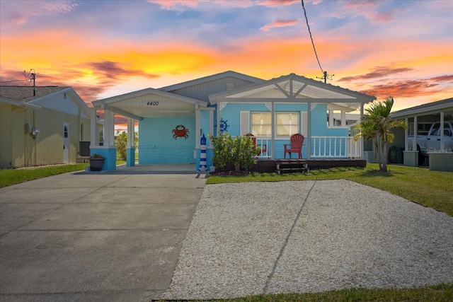 4400 Floramar Ter, New Port Richey, FL 34652 - view of front facade with a front yard, central AC, a carport, covered porch, and driveway