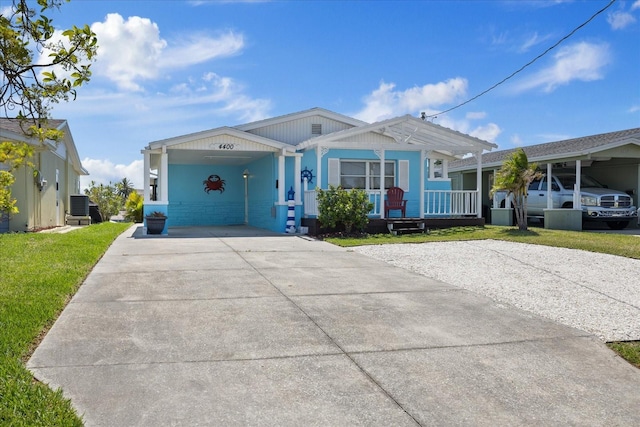 4400 Floramar Ter, New Port Richey, FL 34652 - view of front facade with central AC, a porch, a front lawn, an attached carport, and driveway