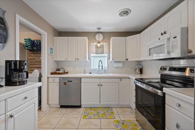 4400 Floramar Ter, New Port Richey, FL 34652 - kitchen with tile countertops, a sink, visible vents, and stainless steel appliances