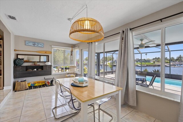 4400 Floramar Ter, New Port Richey, FL 34652 - tiled dining space with a water view, visible vents, and a textured ceiling