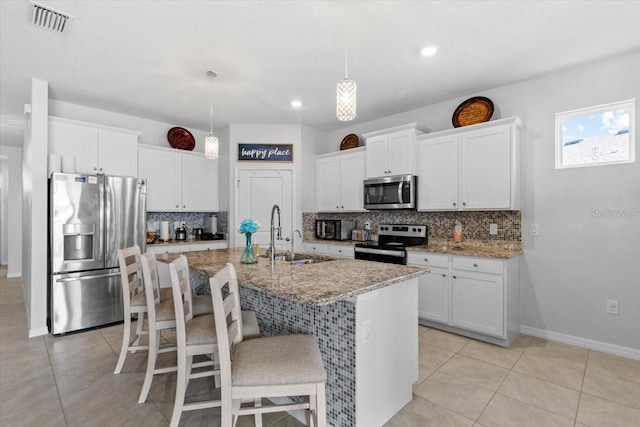 13338 Waterleaf Garden Cir, Riverview, FL 33579 - kitchen with appliances with stainless steel finishes, a sink, backsplash, a kitchen island with sink, and light tile patterned floors