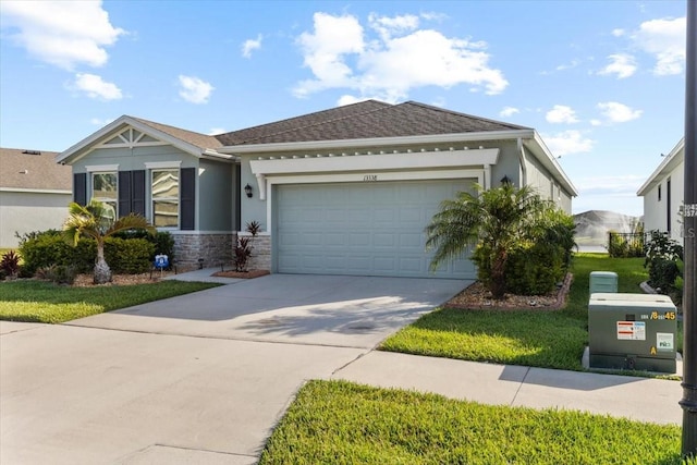 13338 Waterleaf Garden Cir, Riverview, FL 33579 - ranch-style home with driveway, a garage, stucco siding, stone siding, and roof with shingles