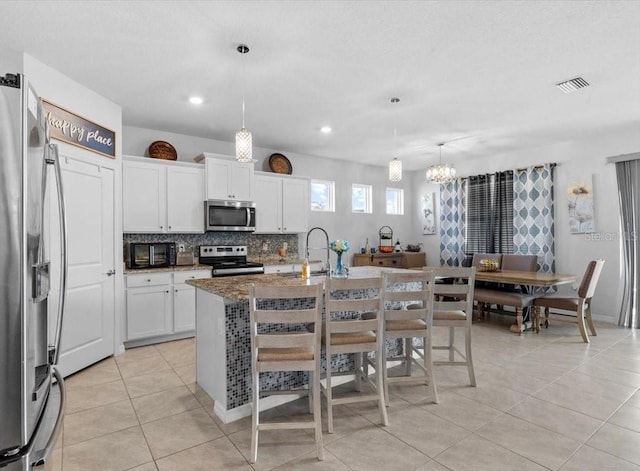 13338 Waterleaf Garden Cir, Riverview, FL 33579 - kitchen with stainless steel appliances, light tile patterned floors, a chandelier, a sink, and recessed lighting